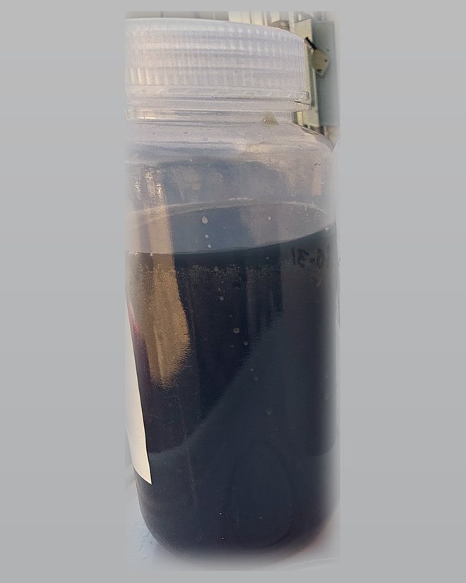 Sample bottle of DVI liquid potash, a dark carbonate solution